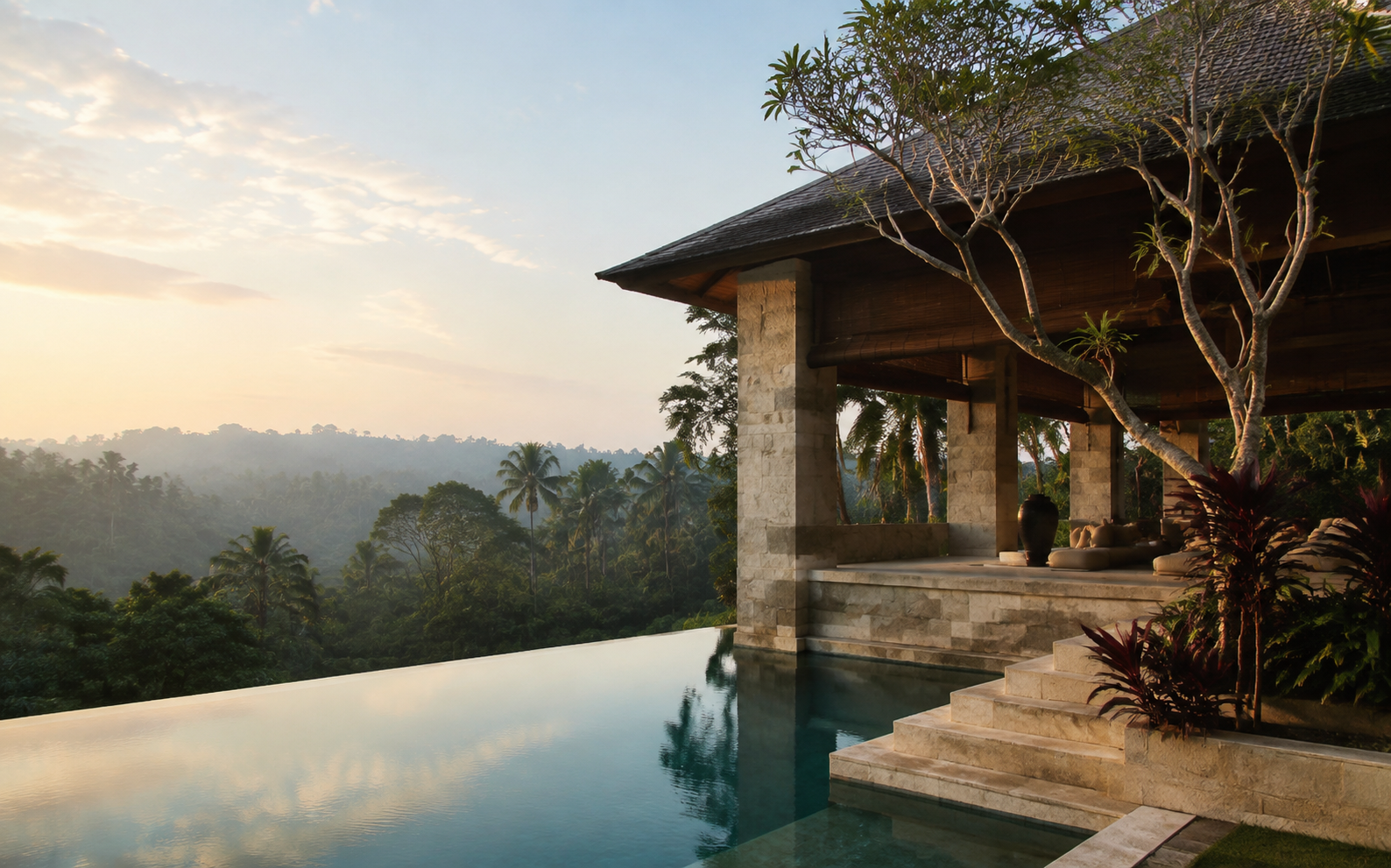 Open-air limestone pavilion and infinity pool overlooking Bali's palm-covered hills